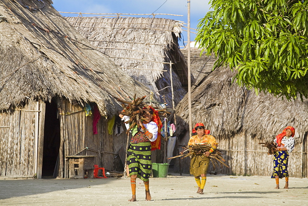 Kuna women carrying wood through village, Wichub-Wala Island, San Blas Islands, Comarca de Kuna Yala, Panama, Central America