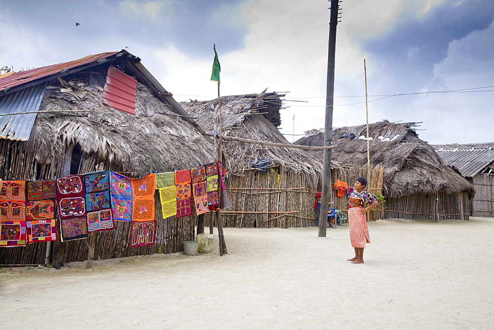 Molas hanging up for sale outside thatched houses, Isla Tigre, San Blas Islands, Comarca de Kuna Yala, Panama, Central America