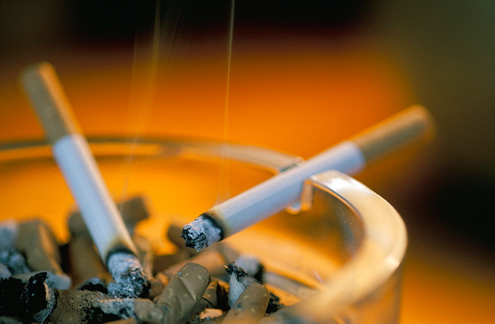 Smouldering cigarettes on ashtray