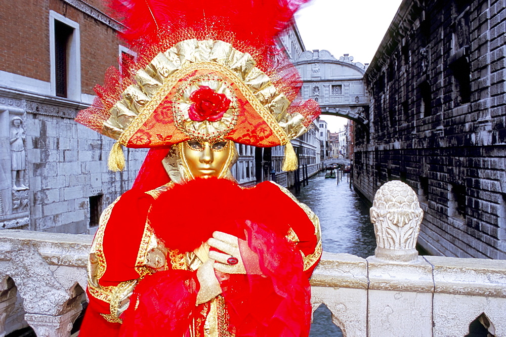 Portrait of a person dressed in mask and costume posing in front of the Bridge of Sighs, Venice Carnival, Venice, Veneto, Italy, Europe