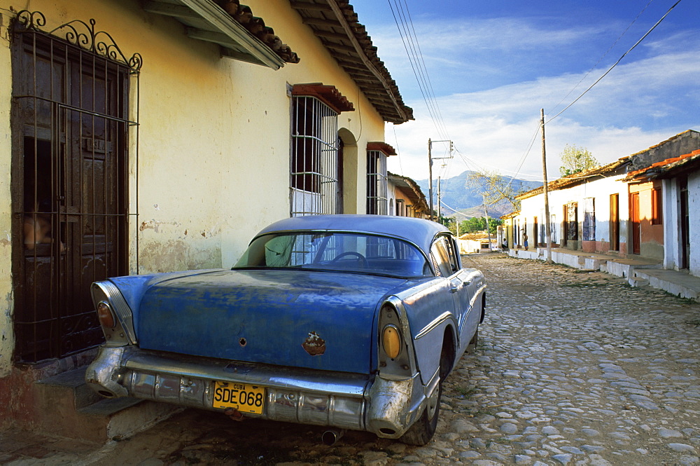 Old American car parked on cobbled street, Trinidad, Cuba, West Indies, Central America