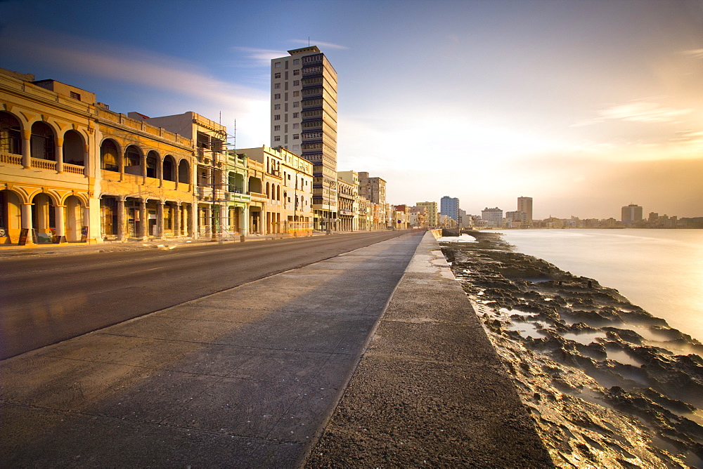 View along The Malecon at dusk showing mix of old and new buildings, Havana, Cuba, West Indies, Central America