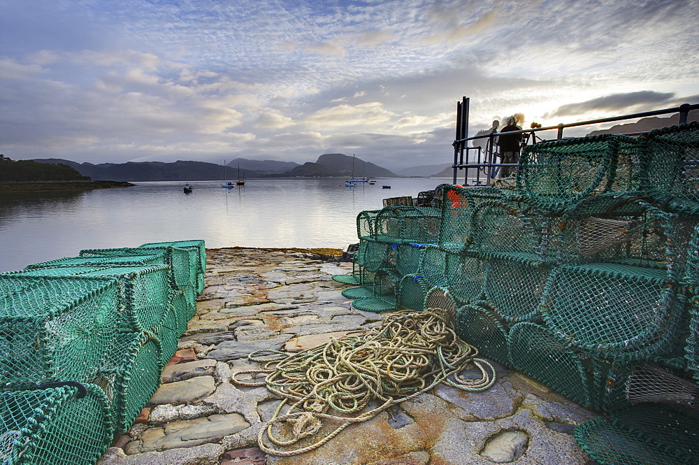 View out to sea from stone slipway at dawn, with lobster pots and ropes in foreground, Plokton, near Kyle of Lochalsh, Highland, Scotland, United Kingdom, Europe