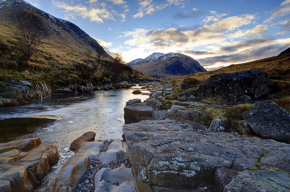 Winter view along partly-frozen River Etive towards distant mountains, Glen Etive, Rannoch Moor, near Fort William, Highland, Scotland, United Kingdom, Europe