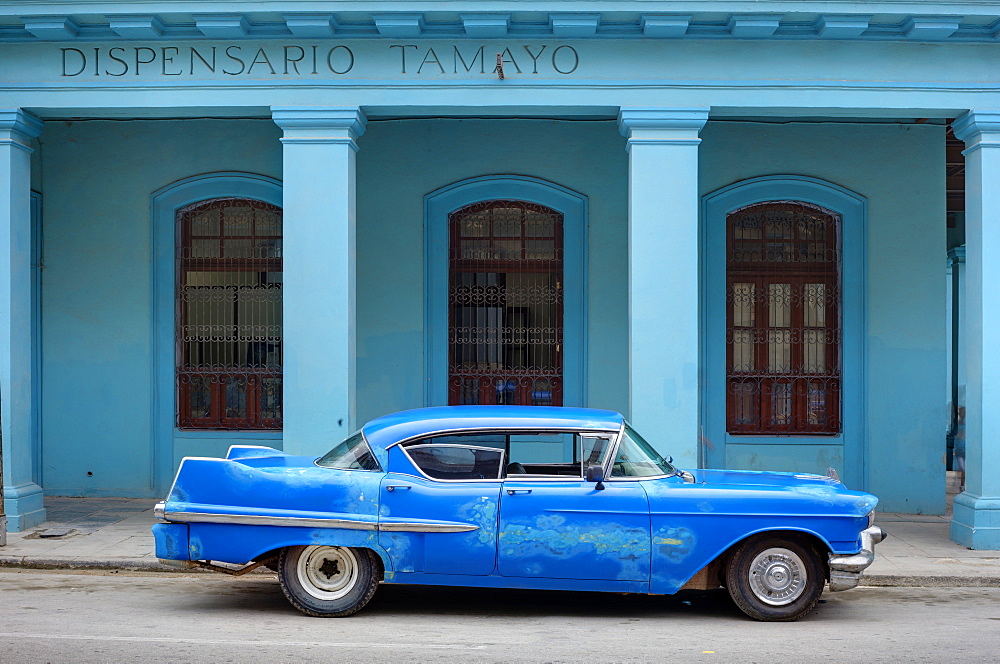 Old blue American car with body repairs parked in front of blue dispensary, Havana Centro, Havana, Cuba, West Indies, Central America