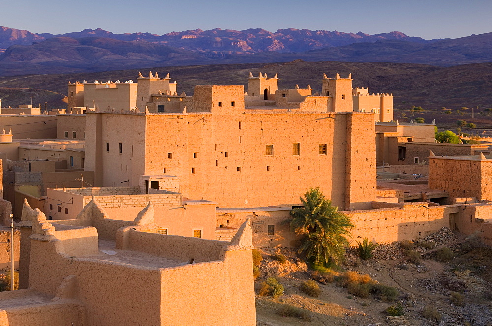 Kasbah bathed in evening light with the Jbel Sarhro Mountains in the distance, Nkob, southern Morocco, Morocco, North Africa, Africa