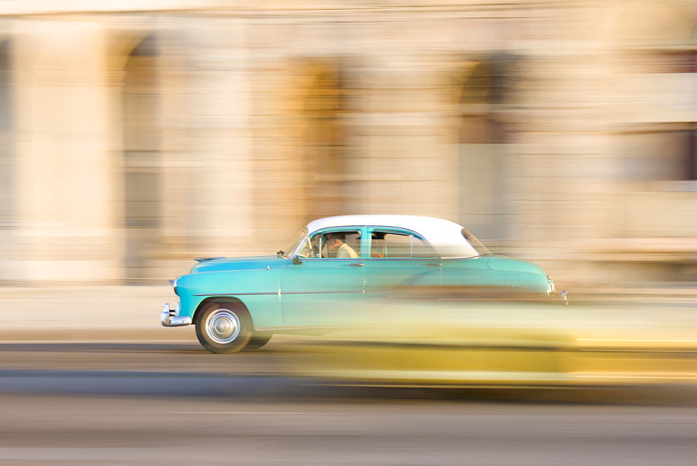 Panned shot of a classic American car on The Malecon, Havana, Cuba, West Indies, Central America