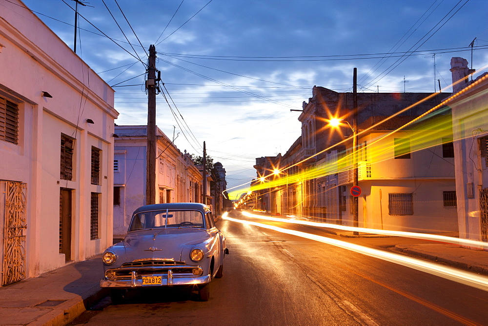 Street scene at night showing Classic American car and the light trails of passing traffic, Cienfuegos, Cuba, West Indies, Central America