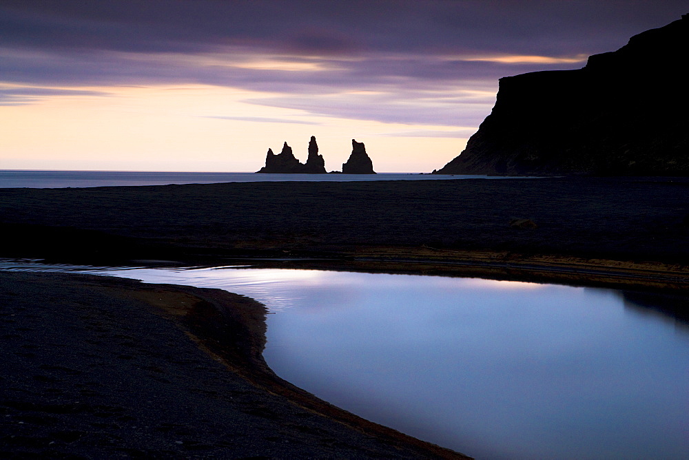 Twilight view towards rock stacks at Reynisdrangar off the coast at Vik, South Iceland, Iceland, Polar Regions