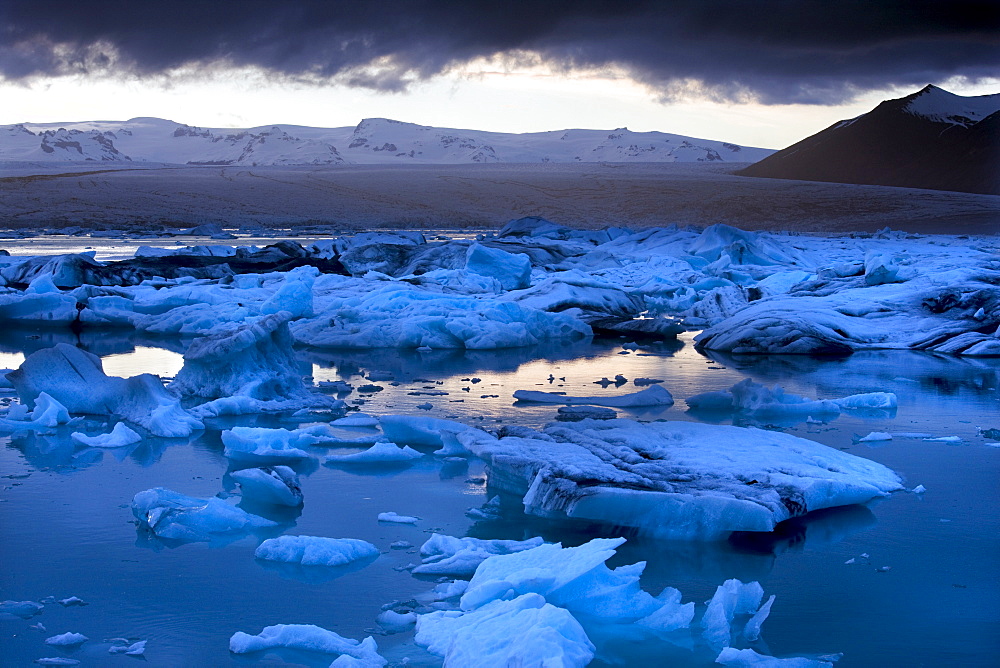 Blue icebergs floating on the Jokulsarlon glacial lagoon at sunset, South Iceland, Iceland, Polar Regions