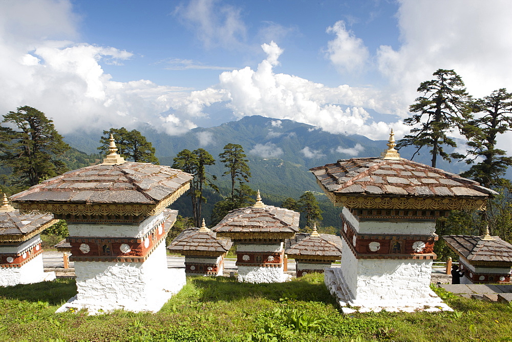 Some of the 108 Chortens located at the summit of the Dochu La Pass with views towards distant forested mountains between Thimpu and Punakha, Bhutan, Himalayas, Asia