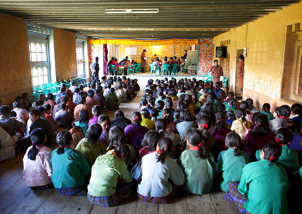 Pupils and teachers in the main hall of their school taking part in a spelling competition, Ura Village, Ura Valley, Bumthang, Bhutan, Asia