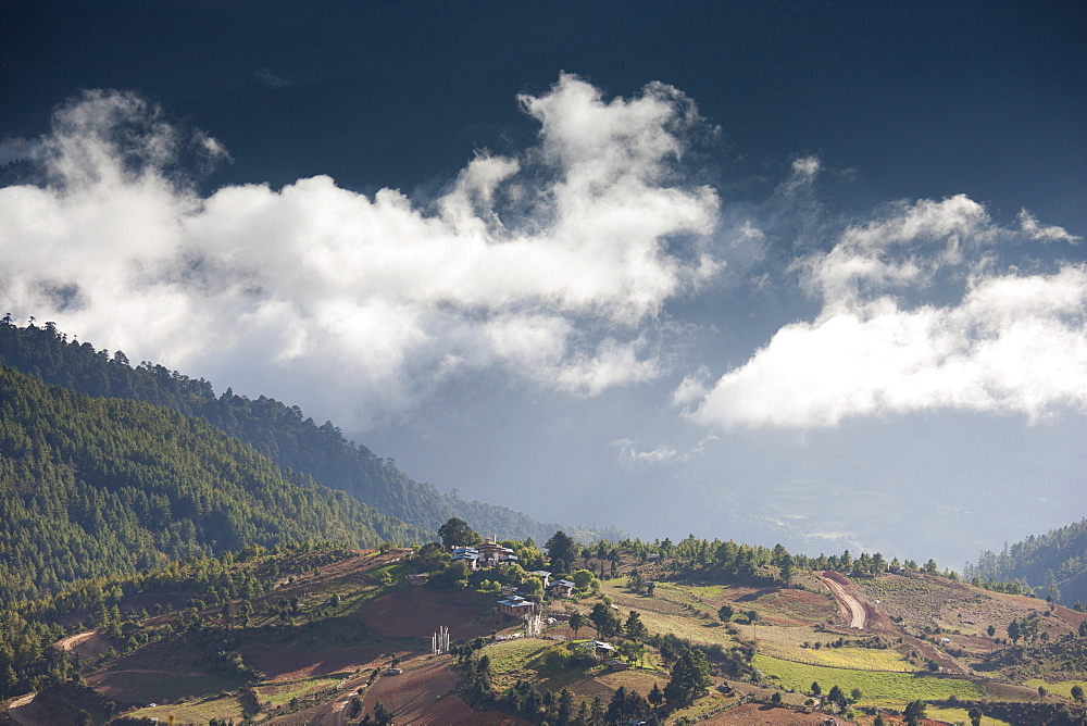 Village of Shingyer against a dramatic backdrop of mountains and clouds, Phobjikha Valley, Bhutan, Himalayas, Asia