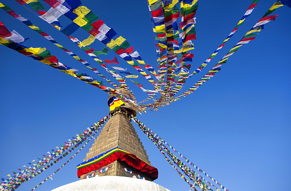 Bodhnath Stupa (Boudhanth) (Boudha), one of the holiest Buddhist sites in Kathmandu, UNESCO World Heritage Site, with colourful prayer flags against clear blue sky, Kathmandu, Nepal, Asia