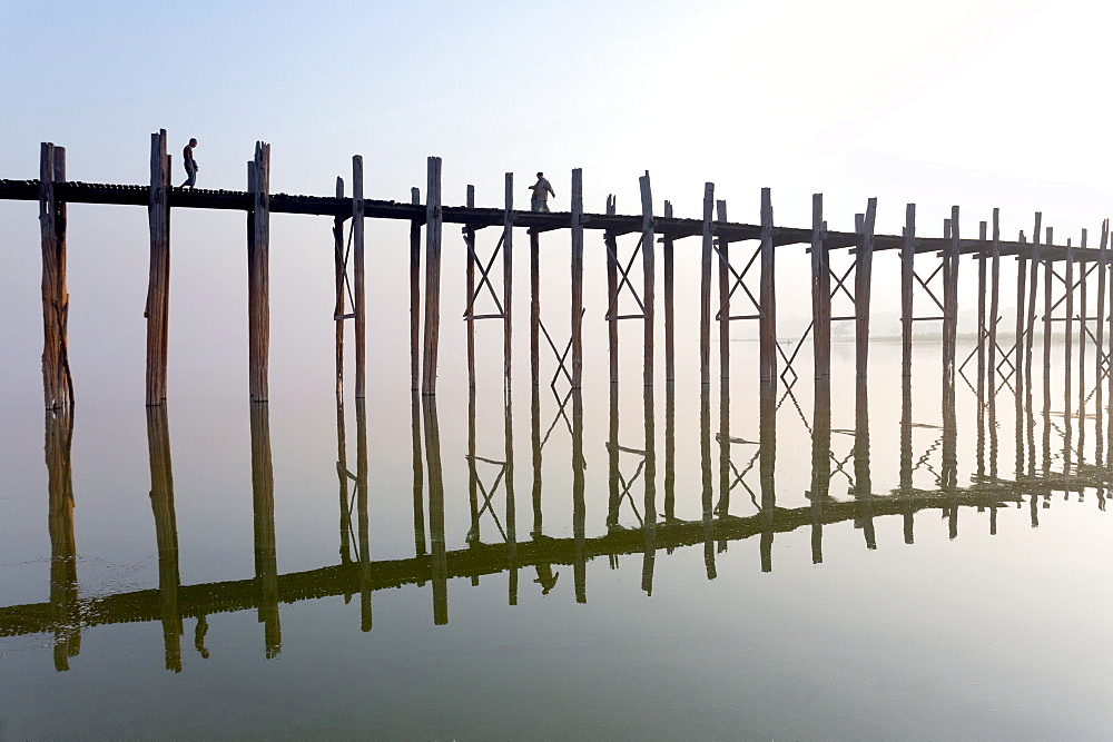 Dawn view of the famous U Bein teak bridge crossing Taungthaman Lake, the bridge reflecting in the calm water, near Mandalay, Myanmar (Burma), Asia