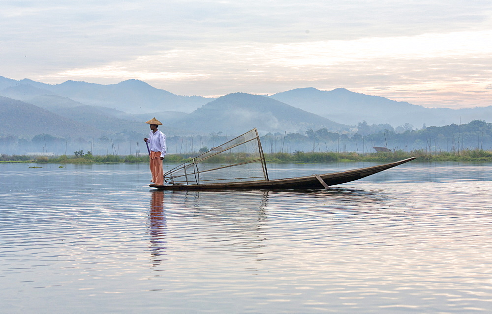 Intha leg rowing fishermen on Inle Lake who row traditional wooden boats using their leg and fish using nets stretched over conical bamboo frames, Inle Lake, Shan State, Myanmar (Burma), Asia