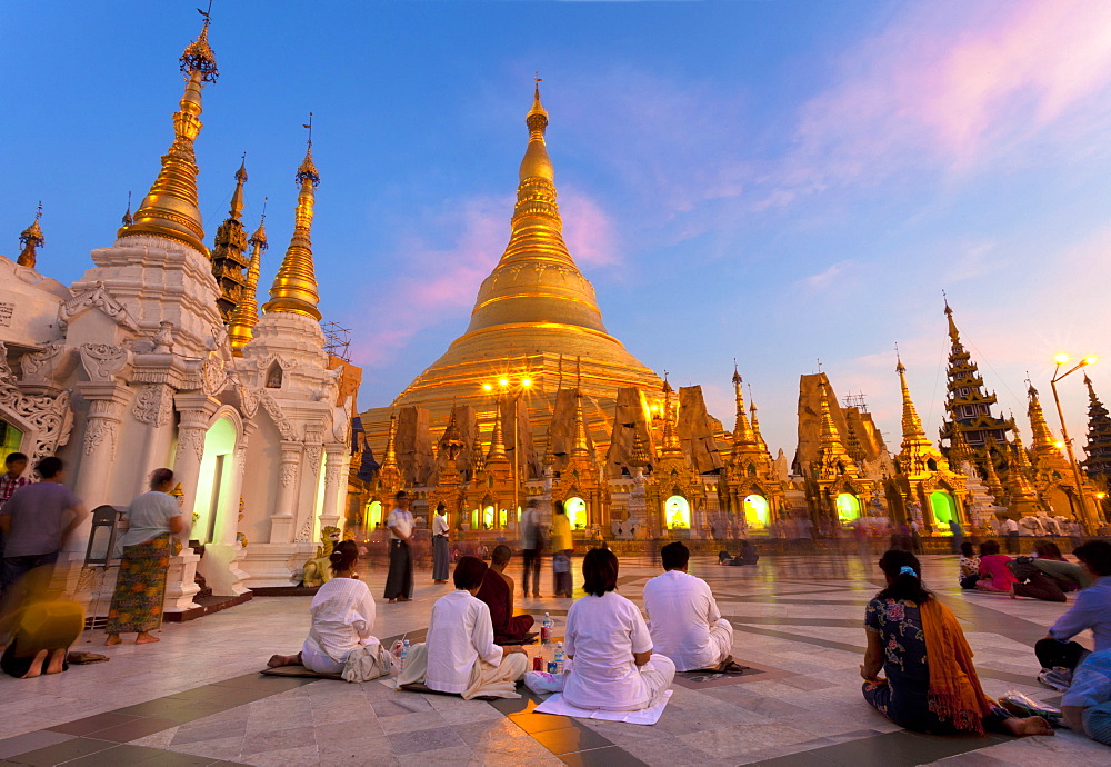 Shwedagon Paya (Pagoda) at dusk with Buddhist worshippers praying, Yangon (Rangoon), Myanmar (Burma), Asia