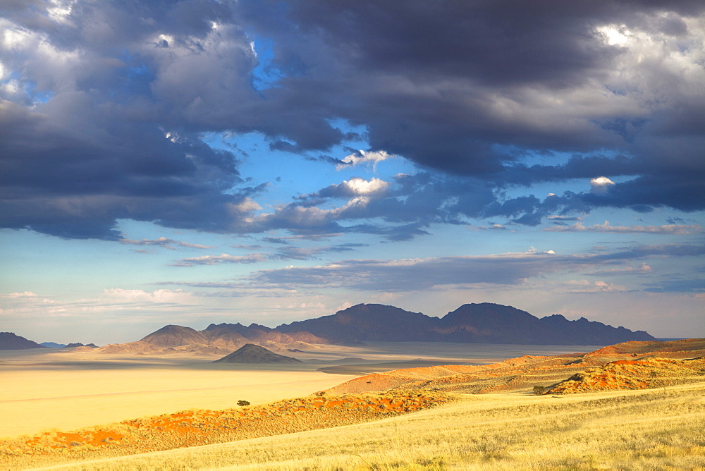 View at dusk over the magnificent desert and mountainous landscape of the Namib Rand game reserve, Namib Naukluft Park, Namibia, Africa