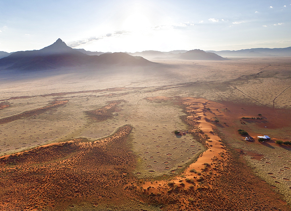 Aerial view from hot air balloon at dawn over magnificent desert landscape of sand dunes, mountains and Fairy Circles, Namib Rand game reserve Namib Naukluft Park, Namibia, Africa