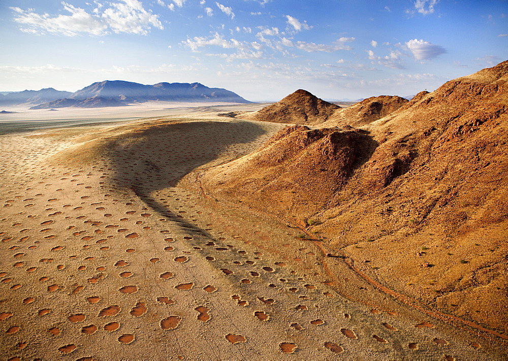 Aerial view from hot air balloon over magnificent desert landscape of sand dunes, mountains and Fairy Circles, Namib Rand game reserve Namib Naukluft Park, Namibia, Africa