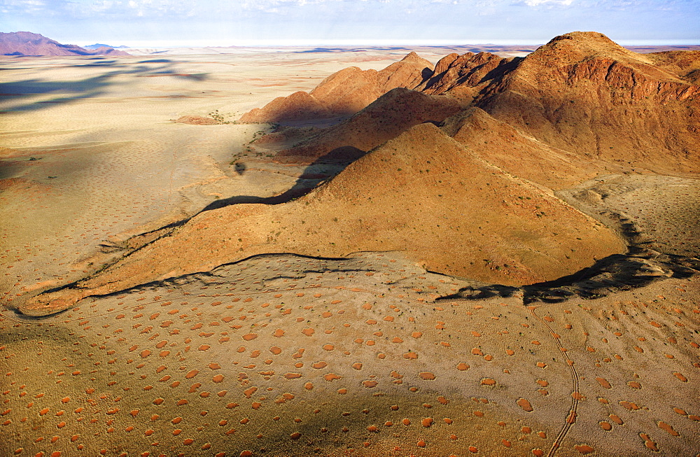 Aerial view from hot air balloon over magnificent desert landscape of sand dunes, mountains and Fairy Circles, Namib Rand game reserve Namib Naukluft Park, Namibia, Africa