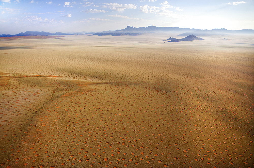 Aerial view from hot air balloon over magnificent desert landscape of sand dunes, mountains and Fairy Circles, Namib Rand game reserve Namib Naukluft Park, Namibia, Africa