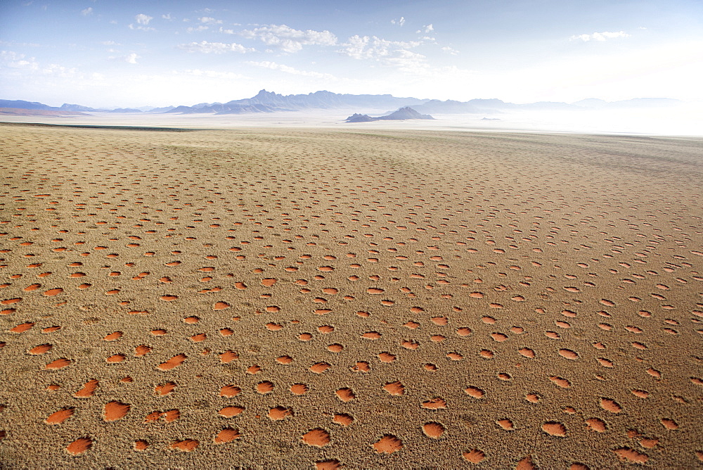 Aerial view from hot air balloon over magnificent desert landscape of sand dunes, mountains and Fairy Circles, Namib Rand game reserve Namib Naukluft Park, Namibia, Africa