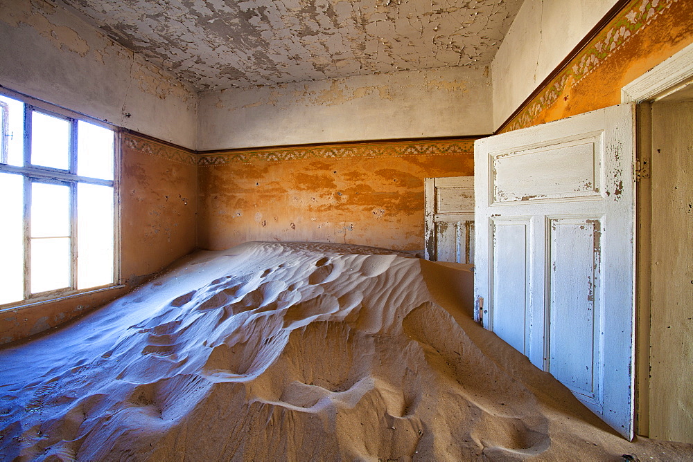 Interior of building slowly being consumed by the sands of the Namib Desert in the abandoned former German diamond mining town of Kolmanskop, Forbidden Diamond Area near Luderitz, Namibia, Africa 