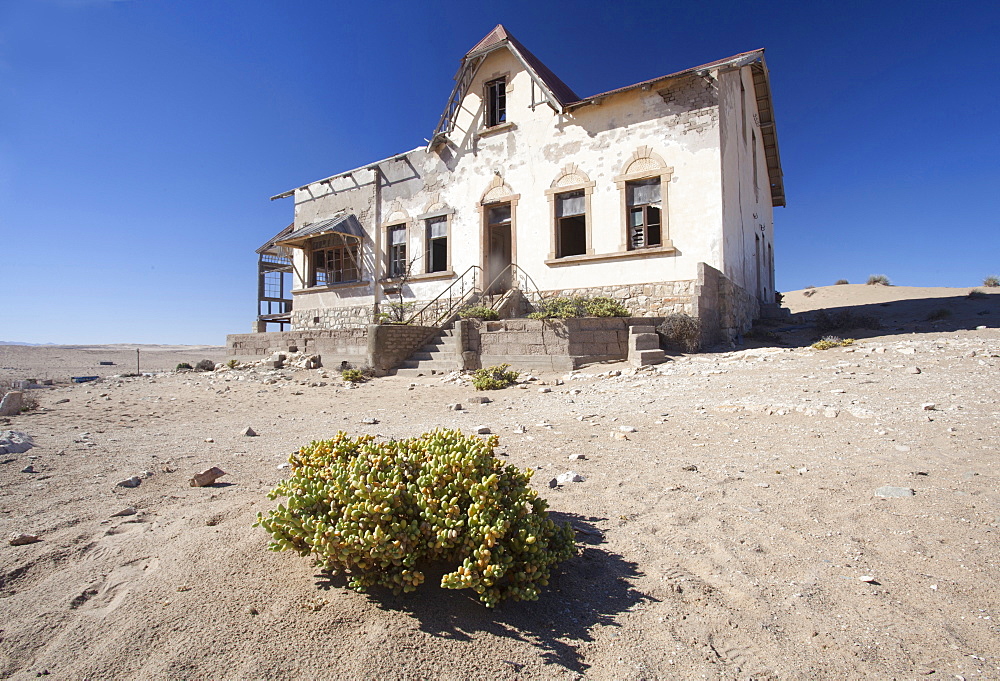 House slowly being reclaimed by the desert in the abandoned former German diamond mining town of Kolmanskop on the edge of the Namib Desert, Forbidden Diamond Area near Luderitz, Namibia, Africa