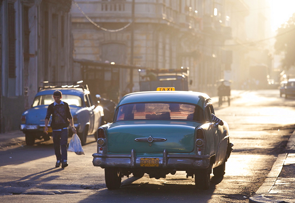 Vintage American car taxi on Avenue Colon during morning rush hour soon after sunrise, Havana Centro, Cuba, West Indies, Central America