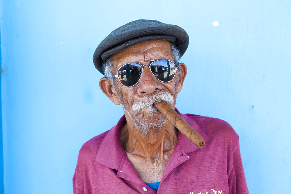 Old man wearing sunglasses and flat cap, smoking big Cuban cigar, Vinales, Pinar Del Rio Province, Cuba, West Indies, Central America