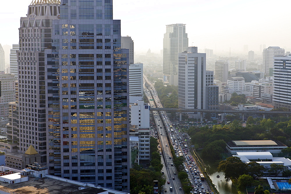 View of high rise buildings and traffic congestion on Rama IV in hazy evening light, from the roof of Hotel Sofitel So, Sathorn Road, Bangkok, Thailand, Southeast Asia, Asia