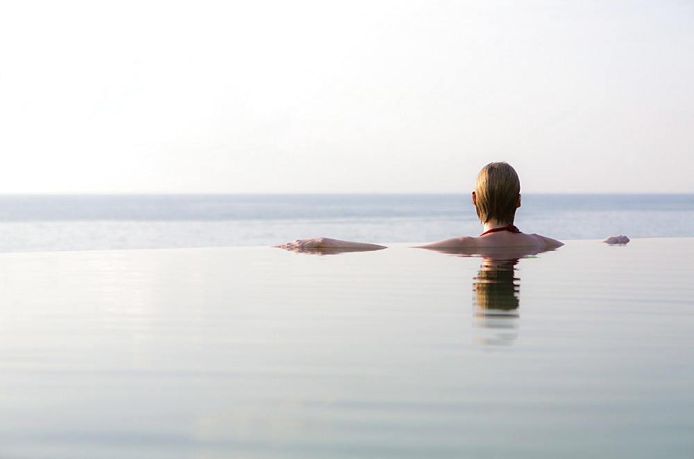 Woman in an infinity pool looking out to sea, Koh Samui, Thailand, Southeast Asia, Asia