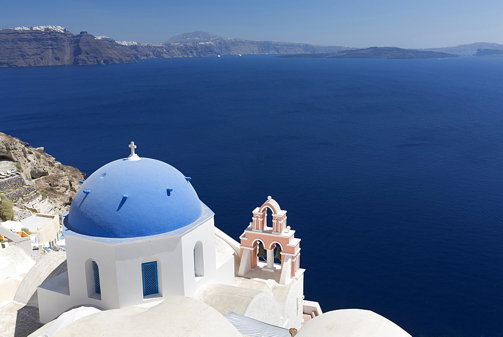 Classic view over the Caldera showing blue domed church and pink belltower, Oia, Santorini, Greek Islands, Greece, Europe