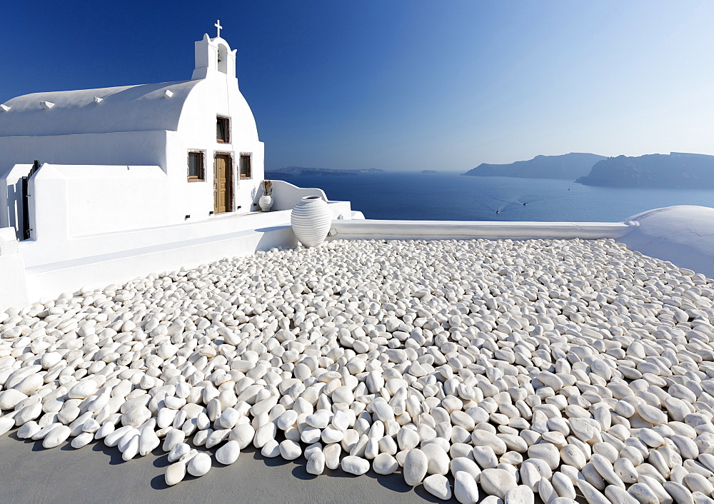 Small whitewashed church against blue sea and sky, Finikia, near Oia, Santorini, Cyclades, Greek Islands, Greece, Europe