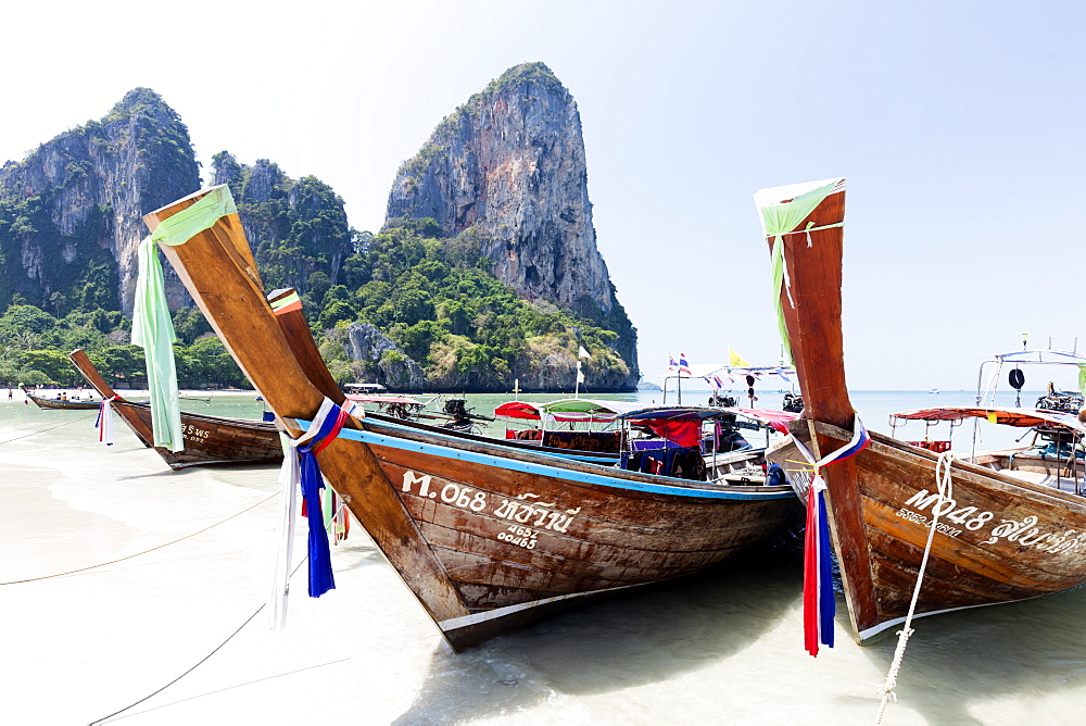 Traditional Longtail boats moored by Railay Beach with limestone cliffs in the background, Ao Nang, Krabi, Thailand, Southeast Asia, Asia