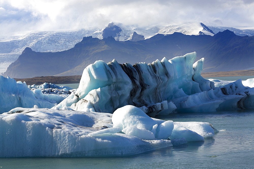 Icebergs on Jokulsarlon Glacial Lagoon, with mountains and glacier behind, South Iceland, Polar Regions