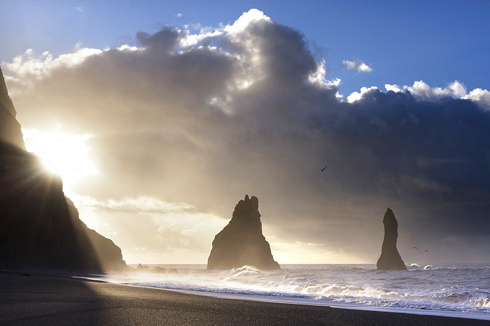 Rock stacks of Reynisdrangar in silhouette at sunrise, from Halsanefs Hellir Beach, near Vik Y Myrdal, South Iceland, Polar Regions