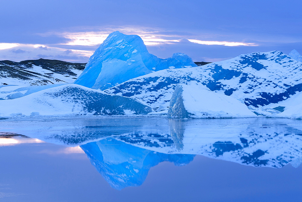 Icebergs covered in dusting of snow, winter, sunset, Jokulsarlon Glacial Lagoon, South Iceland, Polar Regions