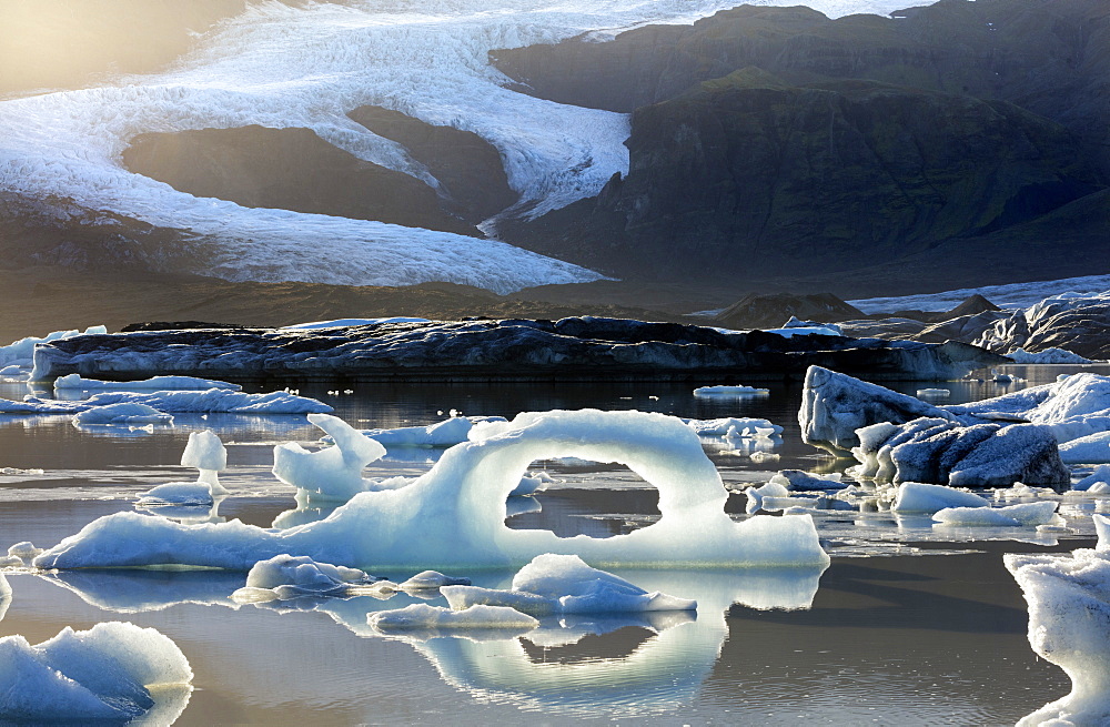 Ice arch among icebergs floating on Fjallsarlon lagoon, near Jokulsarlon, South Iceland, Polar Regions