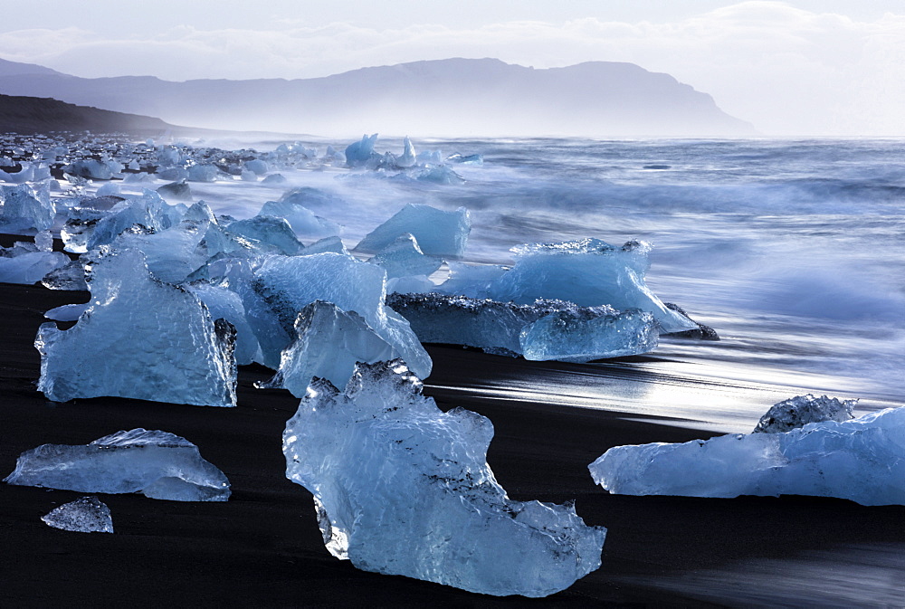 Glacial icebergs washed up from North Atlantic Ocean onto volcanic sand beach near Jokulsarlon, South Iceland, Polar Regions