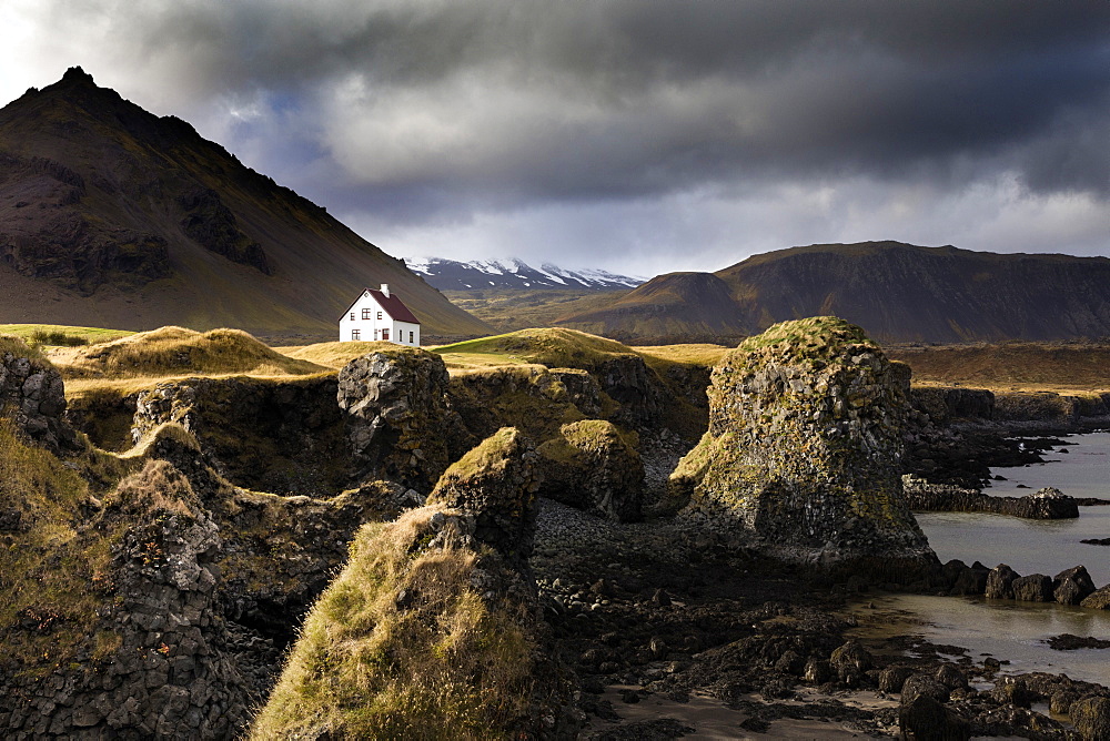 Lone house and sea stacks in stormy weather, Arnastapi, Snaefellsnes Peninsula, Iceland, Polar Regions