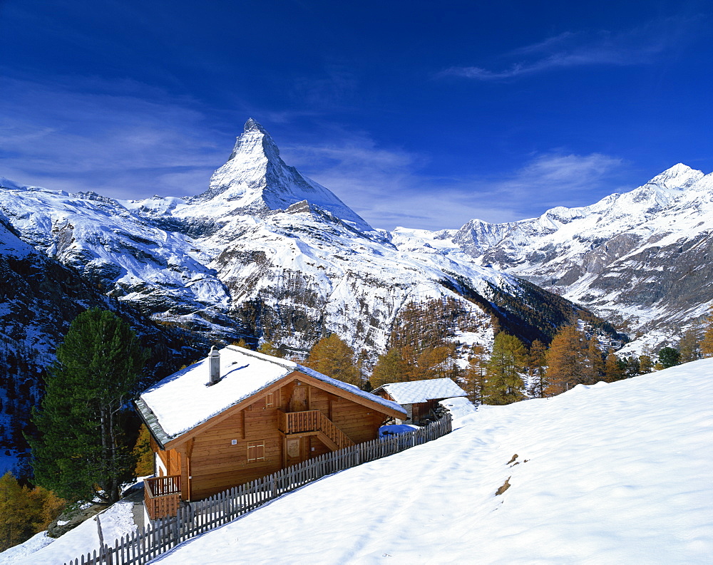 Chalets in a snowy landscape with the Matterhorn peak, near Zermatt, Swiss Alps, Switzerland, Europe