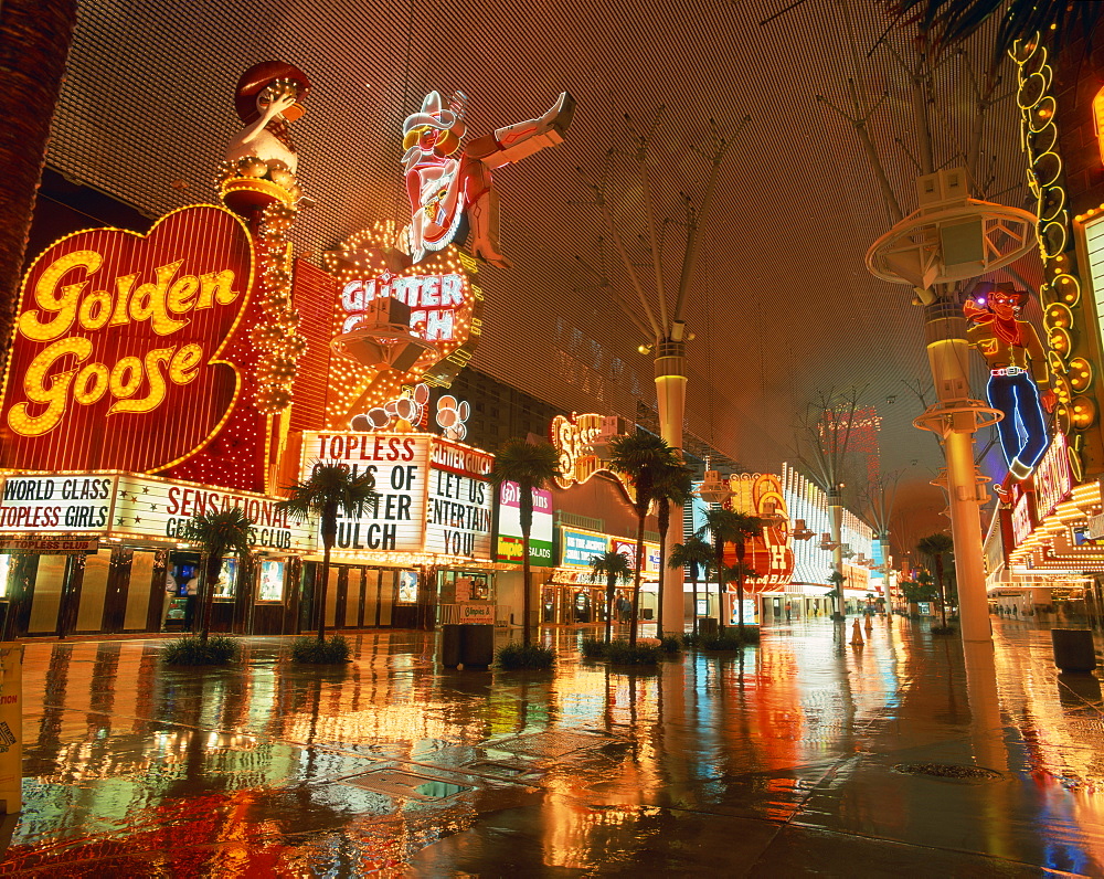 Night reflections on wet street of neon signs along Fremont Street in Las Vegas, Nevada, United States of America, North America