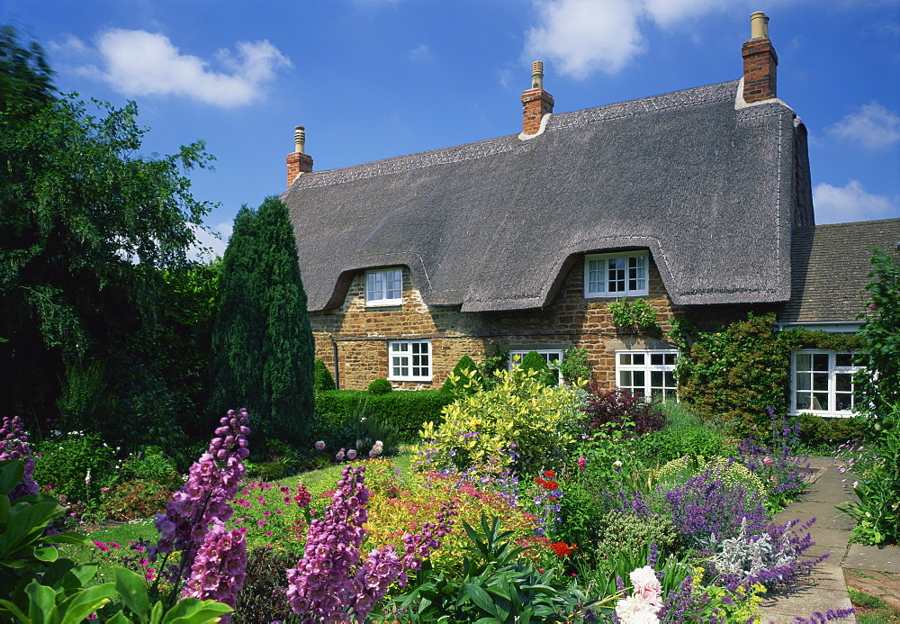 Thatched cottages with gardens full of summer flowers in Hampshire, England, United Kingdom, Europe