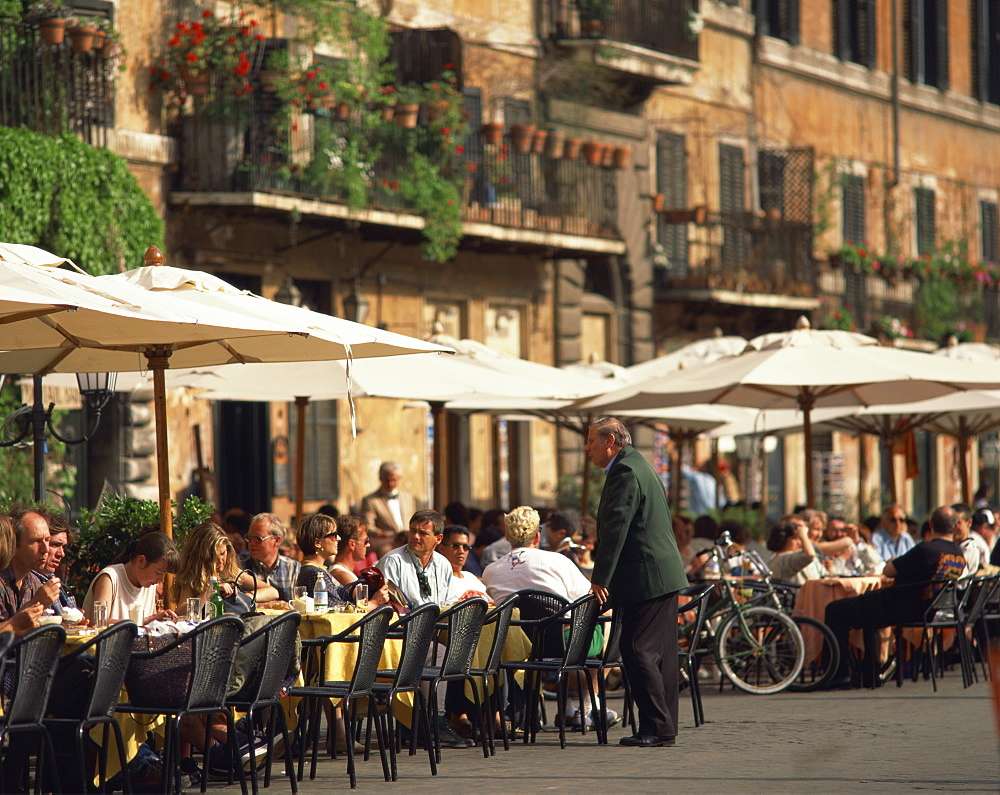 Tourists at a pavement cafe on the Piazza Navona in the city of Rome, Lazio, Italy, Europe