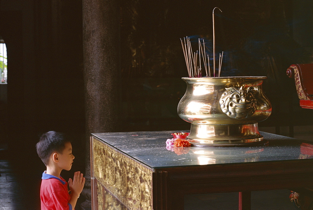 Boy praying at Kek Lok Si Temple, Penang, Kuala Lumpur, Malaysia, Asia