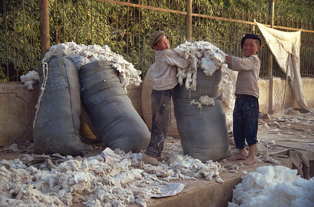 Kids packing wool at end of the day, Sunday Market, Kashgar, China, Asia