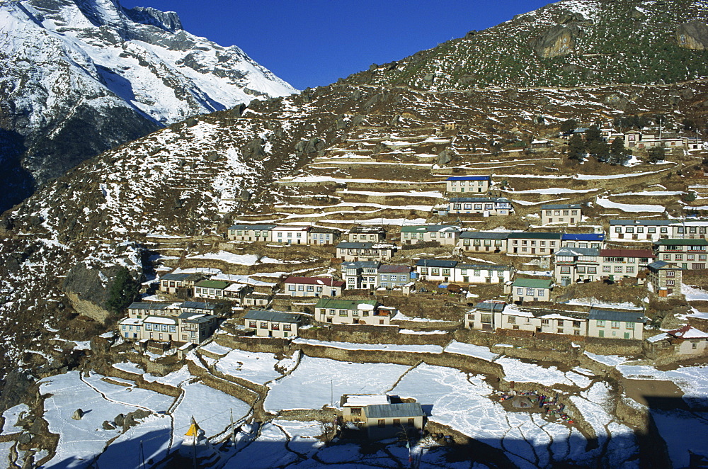 Houses and terraced fields under snow at Namche Bazaar in the Himalayas in Nepal, Asia