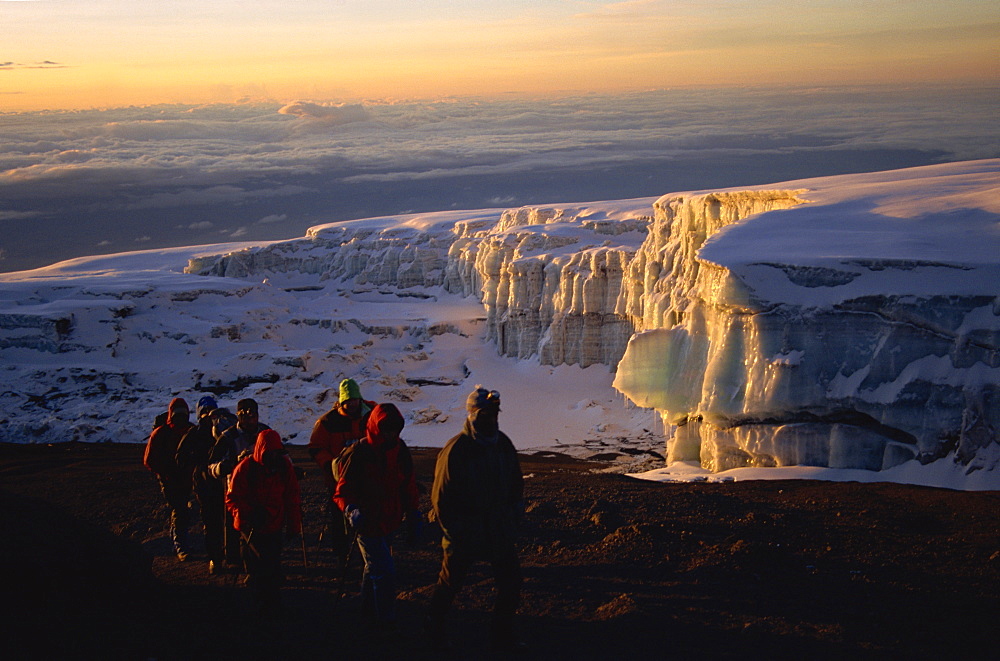 Trekkers and glacier at sunrise on summit of Kibo, 5895m, Kilimanjaro National Park, Tanzania, East Africa, Africa